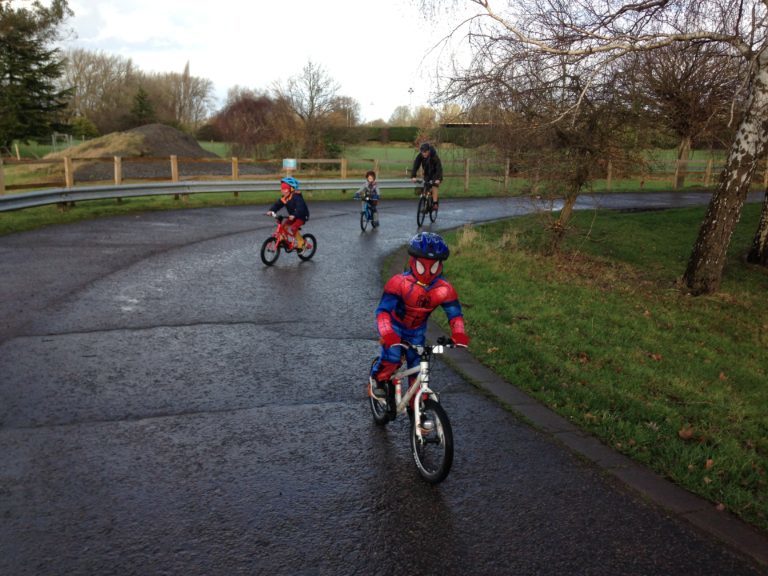 Child in Spiderman outfit cycling